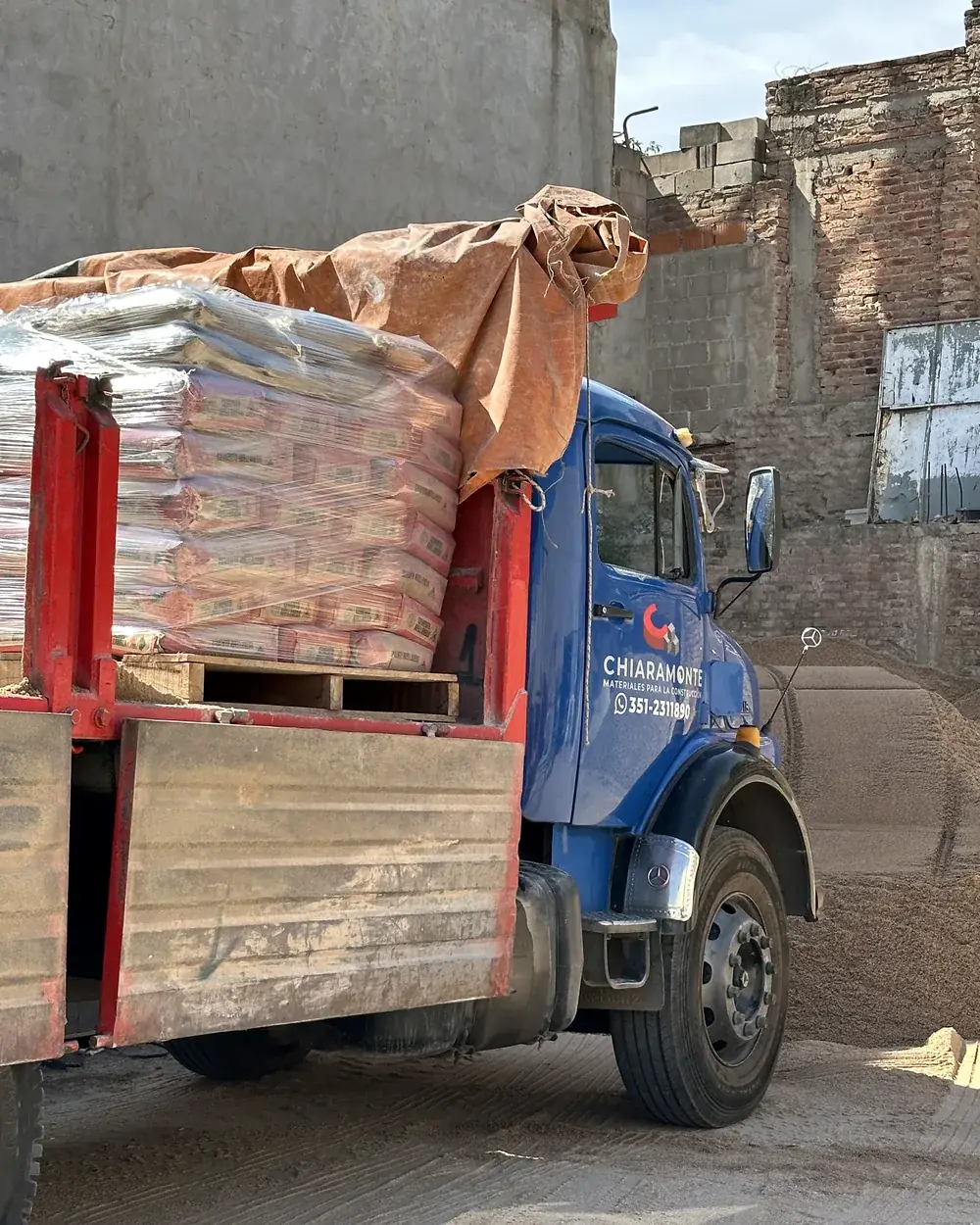 Camión cargado con pallets de cemento saliendo del corralón