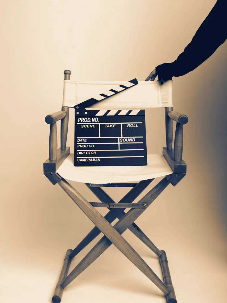 Claqueta de cine apoyada sobre una silla de director